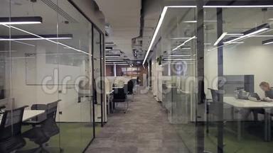 商务中心设有带有玻璃隔断的办公室，员工在其中工作..